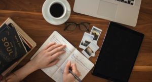 a photo of someone writing in a bullet journal