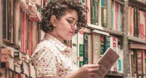 person reading a book in library stacks