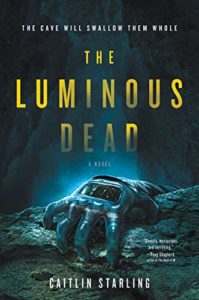 cover of The Luminous Dead by Caitlin Starling; illustration in shades of blue of a glove clinging to the edge of a pit