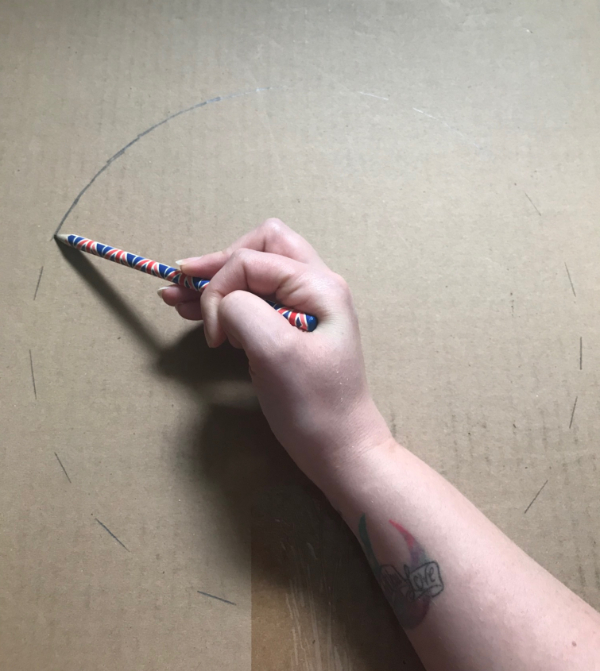 A picture of a hand holding a pencil, drawing a circle