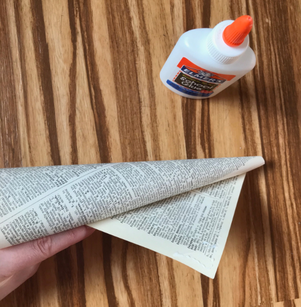 Picture of glue bottle with paper cone, one edge slightly unrolled, with glue on the corner
