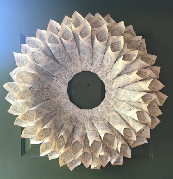 A book page wreath hanging on a door
