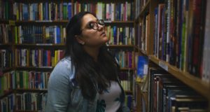 woman browsing books in bookstore or library