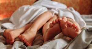 image of two sets of bare legs in bed https://www.pexels.com/photo/couple-love-people-woman-6960001/