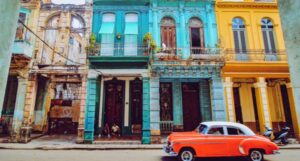 image of an orange classic car in front of colorful buildings on a street in Havana, Cuba https://unsplash.com/photos/-mO6VoL8K2A