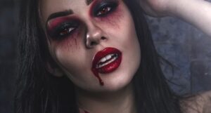 image of a woman with red and black smokey eye makeup, red lipstick, and makeup that looks like blood dripping from her mouth https://unsplash.com/photos/HWUiNmpeHbg