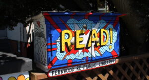 Little Free Library painted with READ! in a comic style