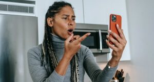 Black woman pointing at phone