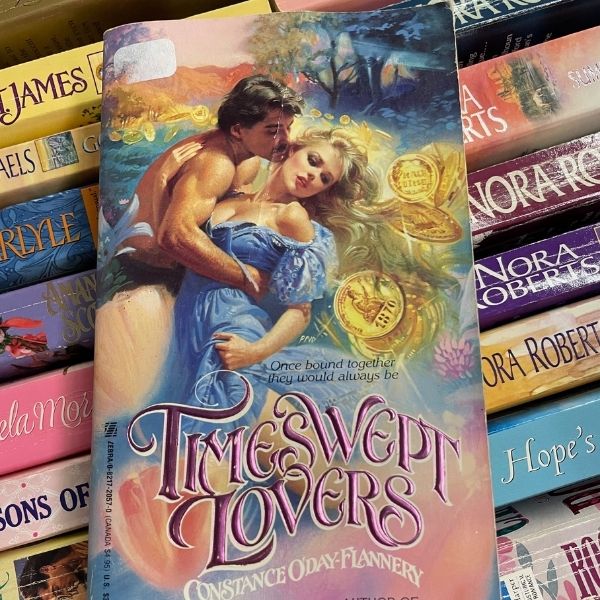The cover of a romance novel called Timeswept Lovers in which the woman's blond hair is blended with an image of gold coins
