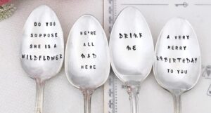 a photo of teaspoons stamped with Alice in Wonderland quotes