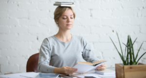 a photo of a white woman balancing books on her head while reading