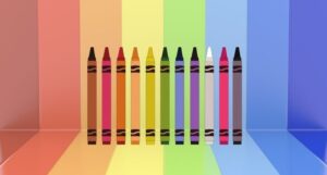 Image of crayons on background of rainbow