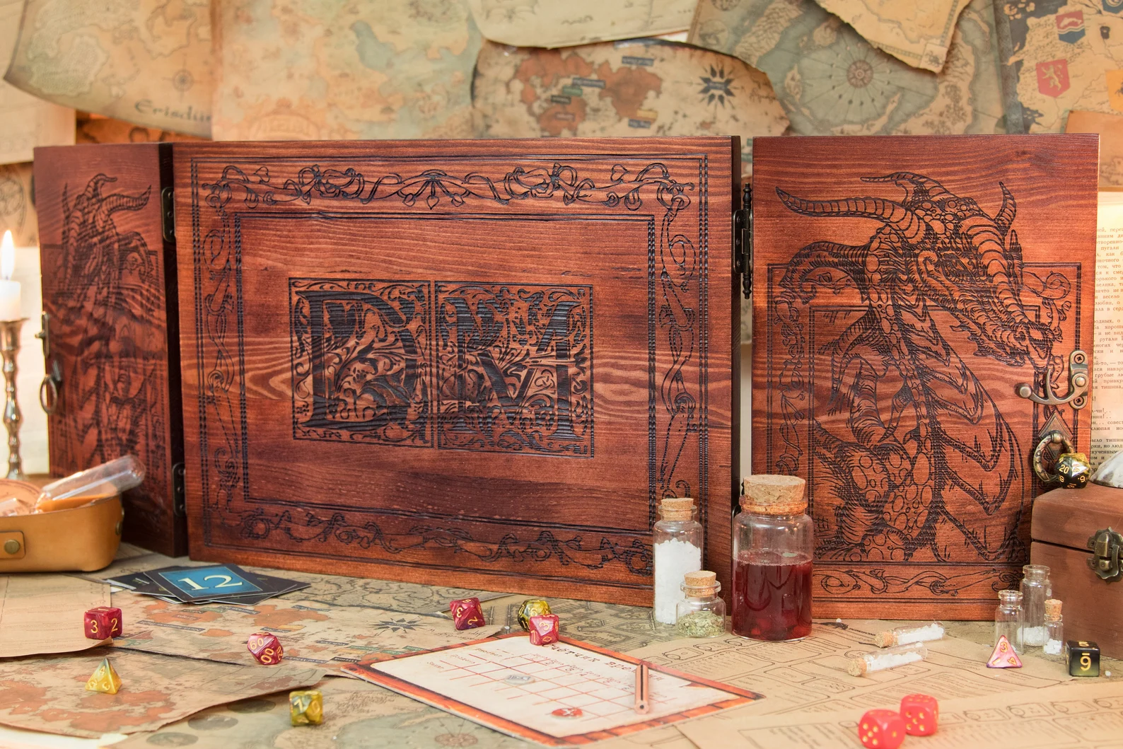 A photo of a wooden Dungeon Master Screen with two dragon engravings and an engraving at the center that reads DM. The front of the photo contains several vials, sheets, cards, and dice. 