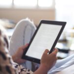 fair-skinned person reading on a tablet