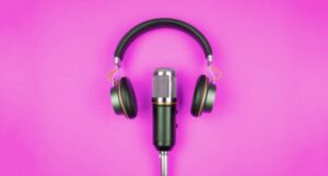 Image of a podcast mic and headphones on a bright pink background