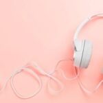 Image of white headphones on a pink background