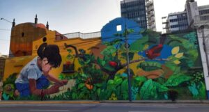 color mural in peru; shows a small girl drawing around plants