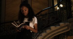 brown-skinned Black woman reading on a staircase