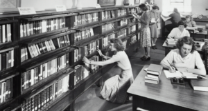 a black and white photo of women in a library