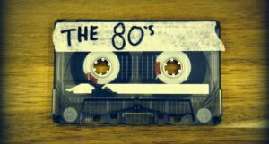 audio cassette tape on a wood surface with the words "the 80s" written on a strip of masking tape