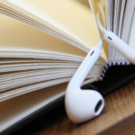 a photo of a book with earbuds being used a bookmark