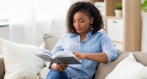 brown-skinned Black woman reading on the couch