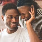 a cropped cover of Learned Reactions showing two Black men leaning their heads together and smiling