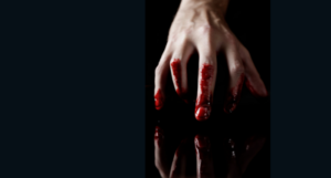 a hand dripping with blood touching a dark surface that reflects it