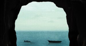 the silhouettes of a small rowboat and what looks like a body floating in a body of water framed by rocks