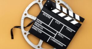 image of a film reel and clapboard on a yellow background