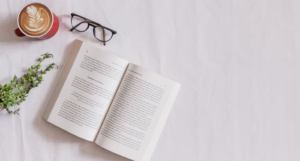 a book with coffee and glasses beside it