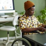 Image of a Black man in a wheelchair at an office
