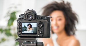 Image of a Black woman in front of a camera
