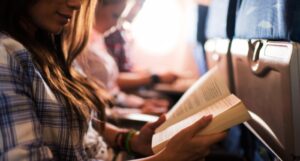 a photo of a woman reading on a plane