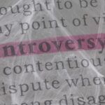 Image of the word "controversy" highlighted in pink, with a spiderweb overlaid on the word