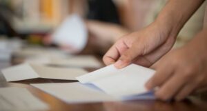 hands folding a piece of paper at a desk