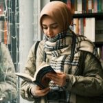 a woman reading a hijab and scarf reading in a bookstore