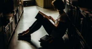 young woman sitting and reading in a library