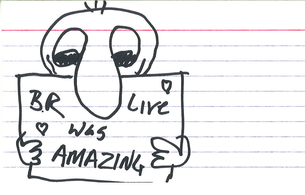 sketch of a person holding a sign that says "BR Live was AMAZING" with little hearts in the corners