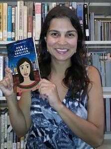 Diverse Librarian Paula Pereira holding her book