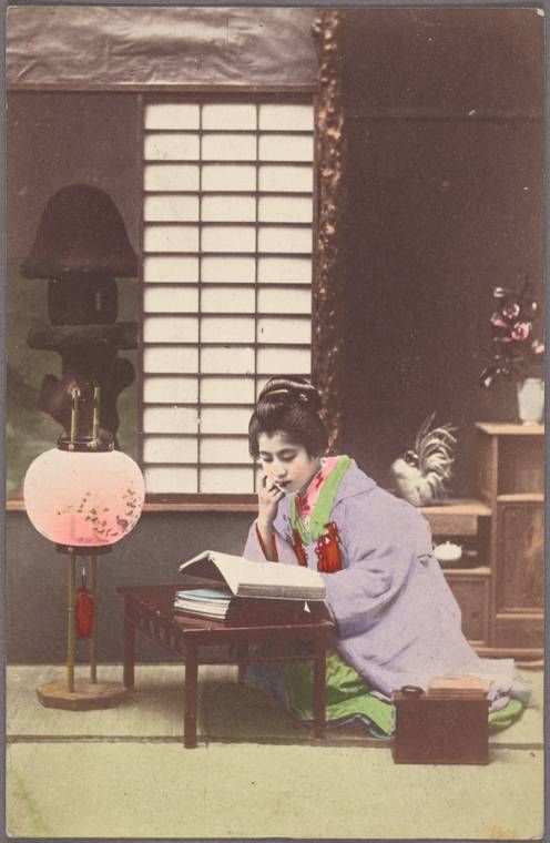 Young woman reading near lamp
