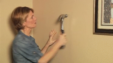 woman hammer into wall