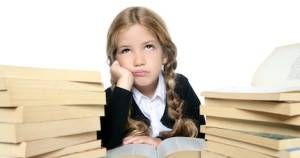 little unhappy sad student blond braided girl bored with stacked books on white background