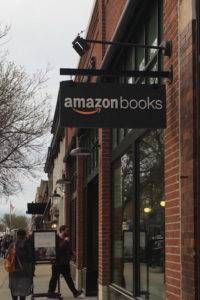 brick facade of building with hanging sign reading amazon books