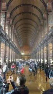 Library with high ceilings and a crowd of people taking pictures.