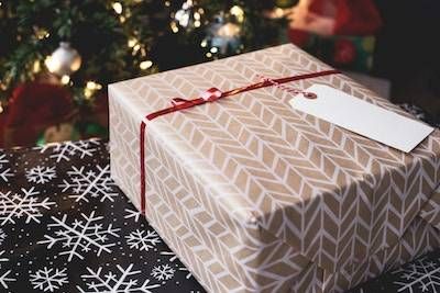 A gift wrapped box tied with a red ribbon.