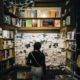 A person looks at a cork board covered in sticky notes in a bookstore.