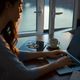 photo of woman writing on laptop