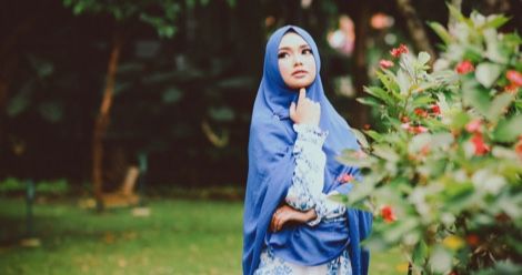 Cute hijab girl with camera and peace sign female photographer