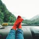 Feet on car dashboard with forest background